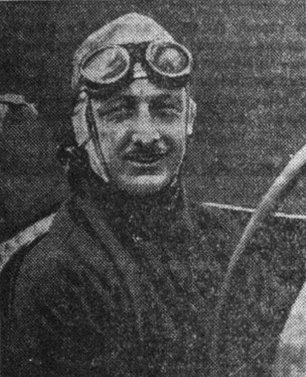 Newspaper portrait of Tim Birkin in a leather helmet with goggles pushed up on his forehead, smiling, with a moustache
