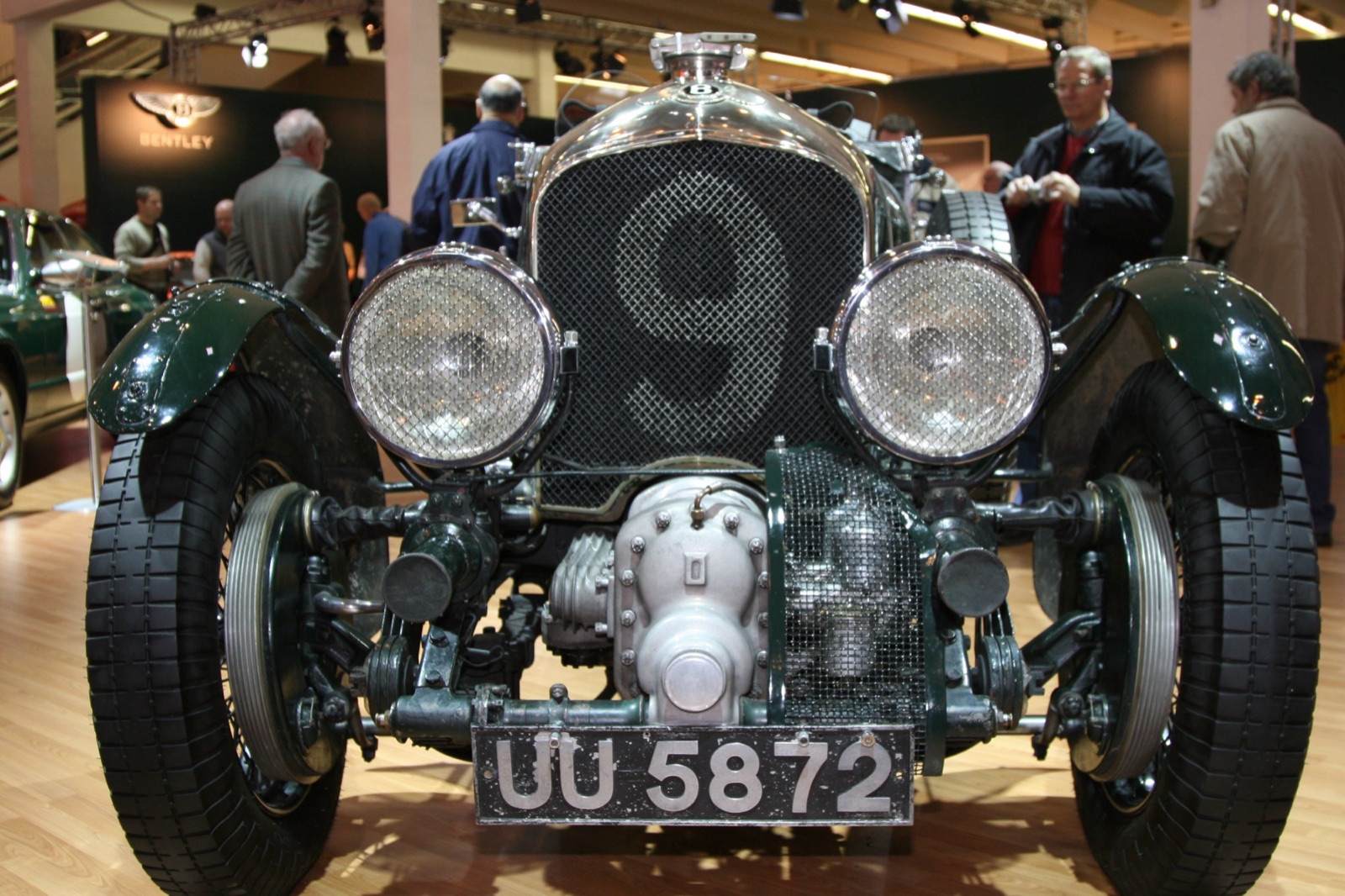 Front of a green Blower Bentley numbered 9 on its radiator mesh, with the finned Roots supercharger casing between the front wheels below the radiator and the registration plate UU 5872