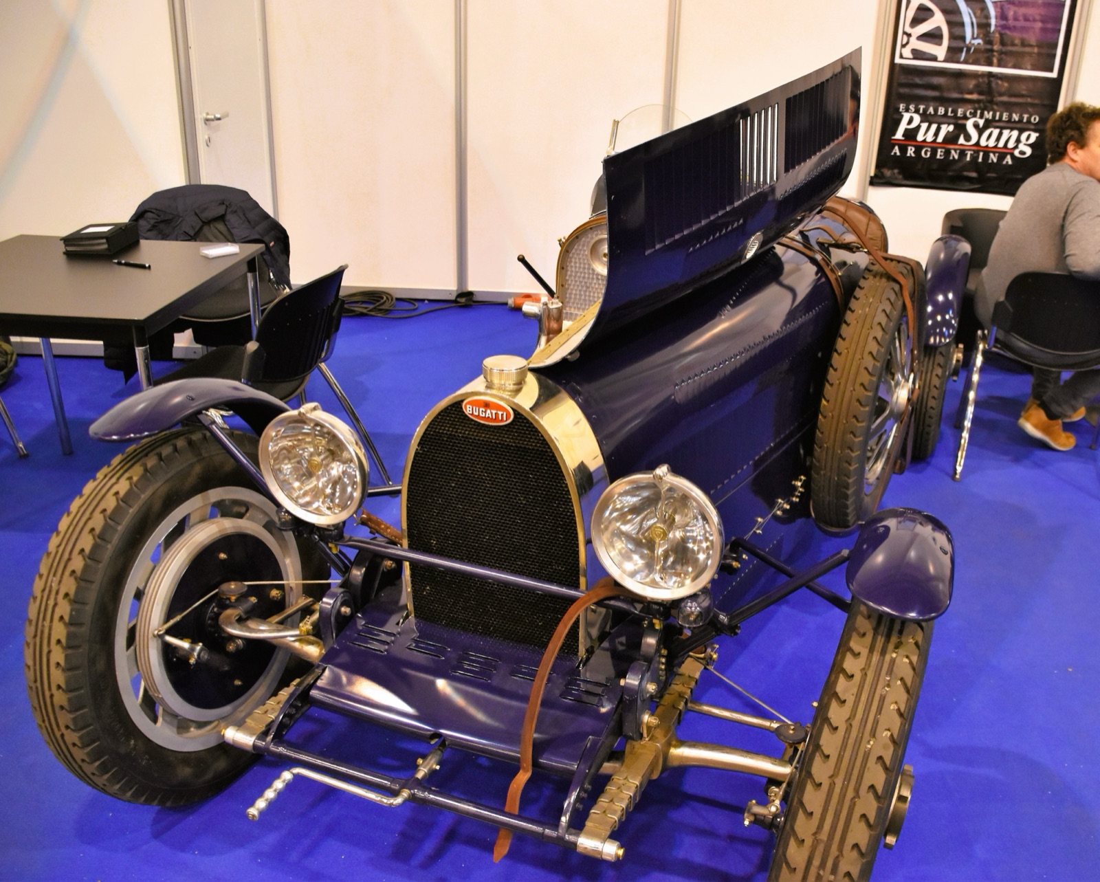 Dark blue Bugatti Type 35 recreation with bonnet open and lamps fitted, on an exhibition stand under a Pur Sang Argentina banner
