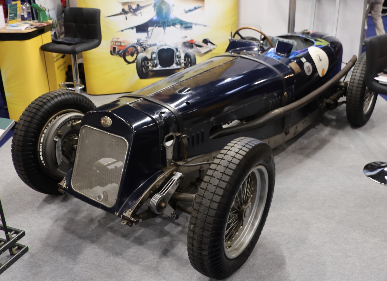 Dark blue Delage 15 S8 with an unpainted bonnet panel and a mesh radiator grille, shown on a museum stand
