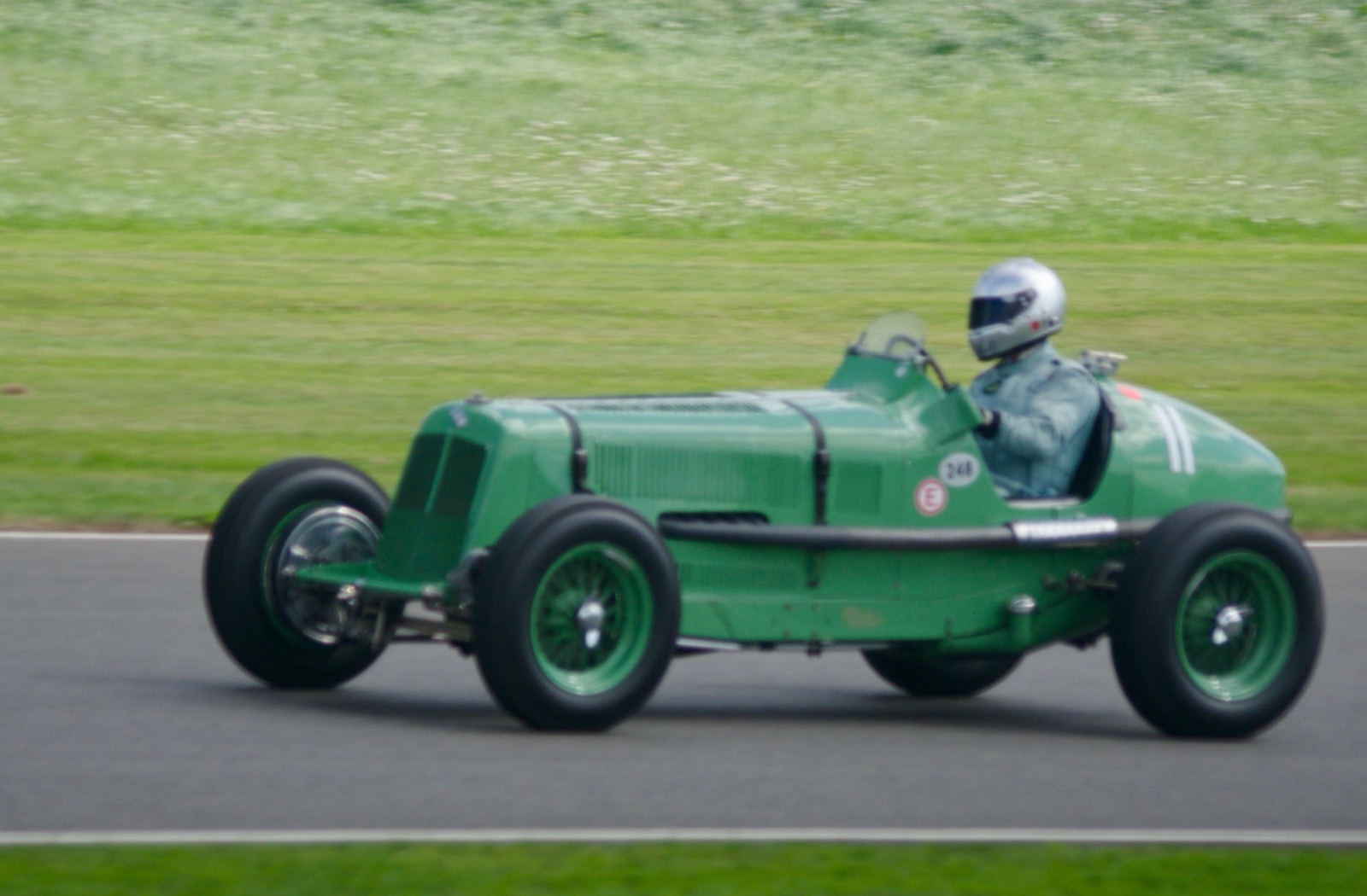 Green ERA A-type R3A single-seater at speed on the Goodwood circuit, driver in a silver helmet