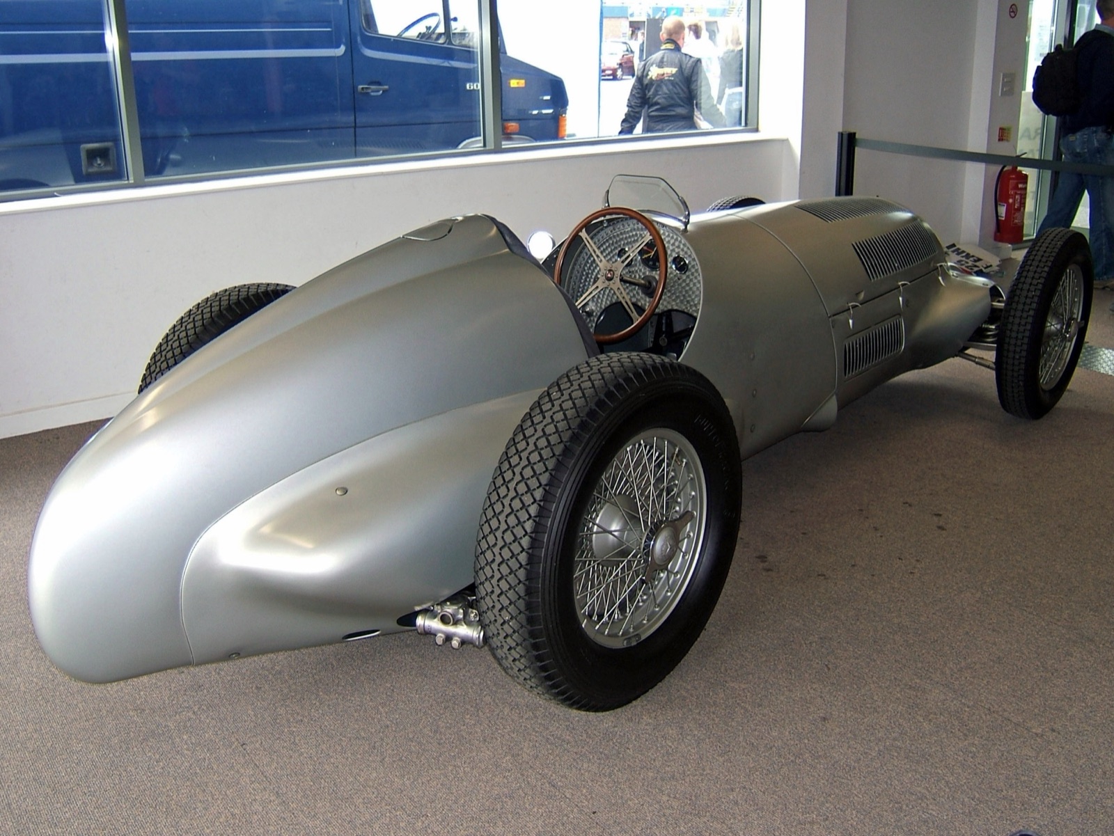 Silver Mercedes-Benz W125 seen from the rear quarter, showing the tail, cockpit and wire wheels