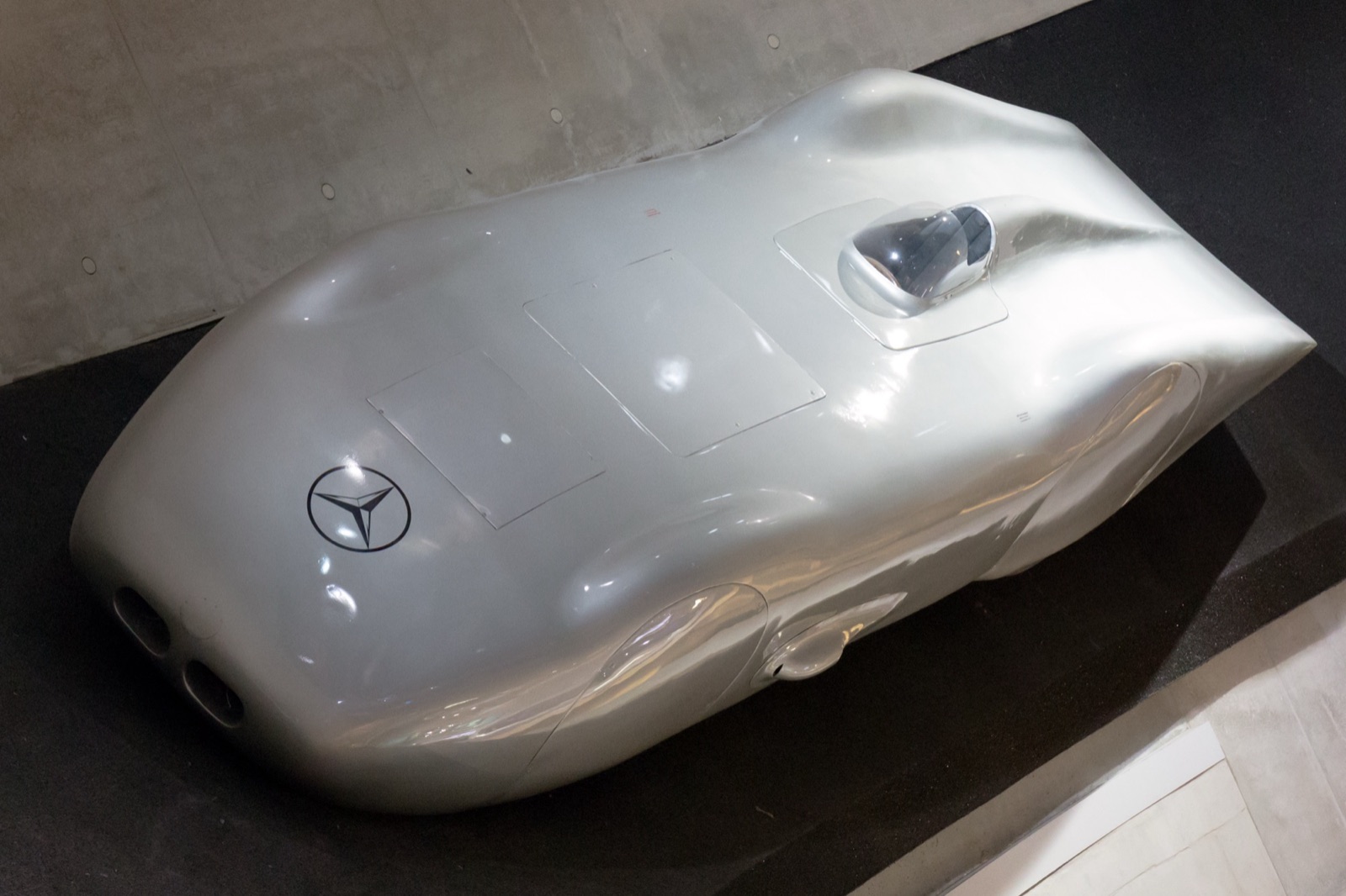 The silver, fully enclosed Mercedes-Benz W125 record car seen from above, with its bubble windscreen and two small air intakes in the nose