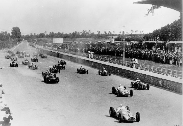 Black-and-white photograph of the start of the 1939 Tripoli Grand Prix, two silver Mercedes-Benz W165s at the front of a field of racing cars beside a packed grandstand