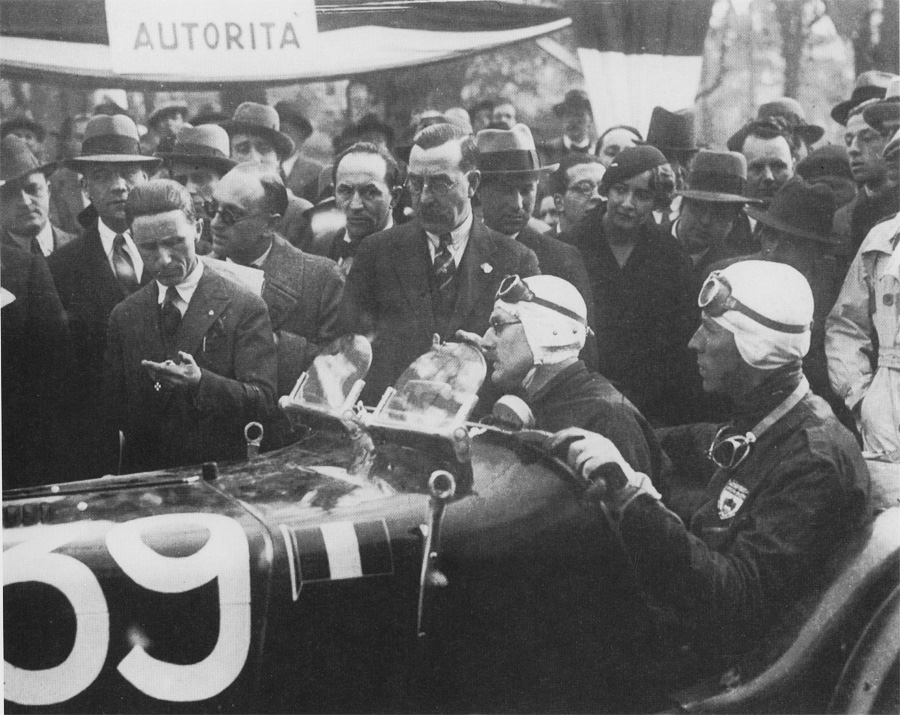George Eyston and Count Lurani seated in the MG K3 Magnette numbered 39, surrounded by officials and spectators in hats at the 1933 Mille Miglia