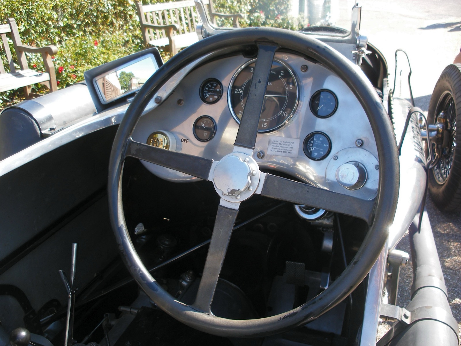 The cockpit of the Napier-Railton: a large four-spoke steering wheel in front of an aluminium dash with a big tachometer and smaller gauges